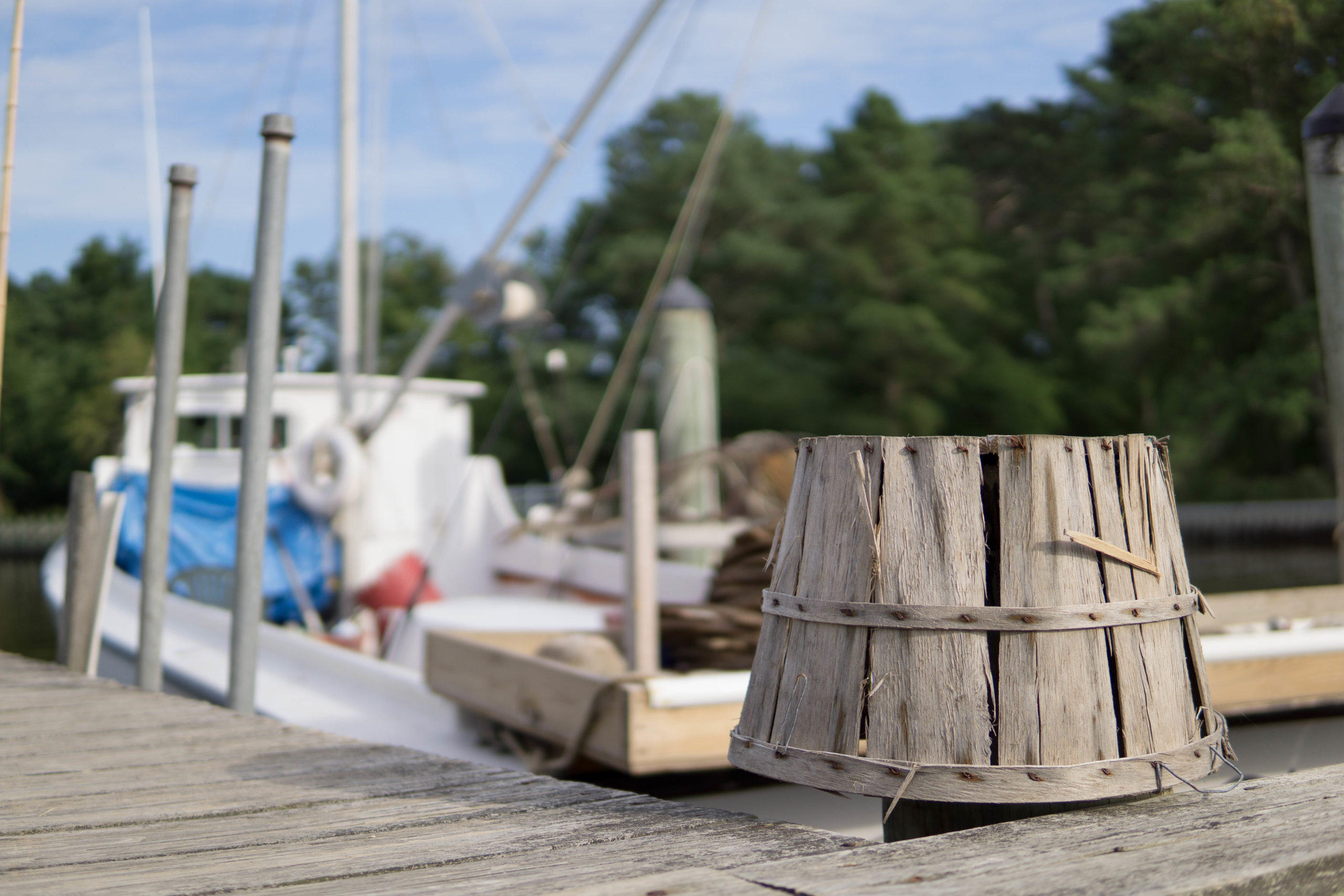 Face-down bucket on dock by boat. 